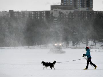 Una mujer sale a pasea a su perro mientras las bajas temperaturas del viento alcanzan los -34º en Minnesota (EEUU)
