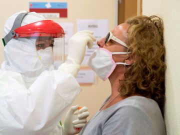 Una enfermera del 061 hace una prueba PCR a una mujer