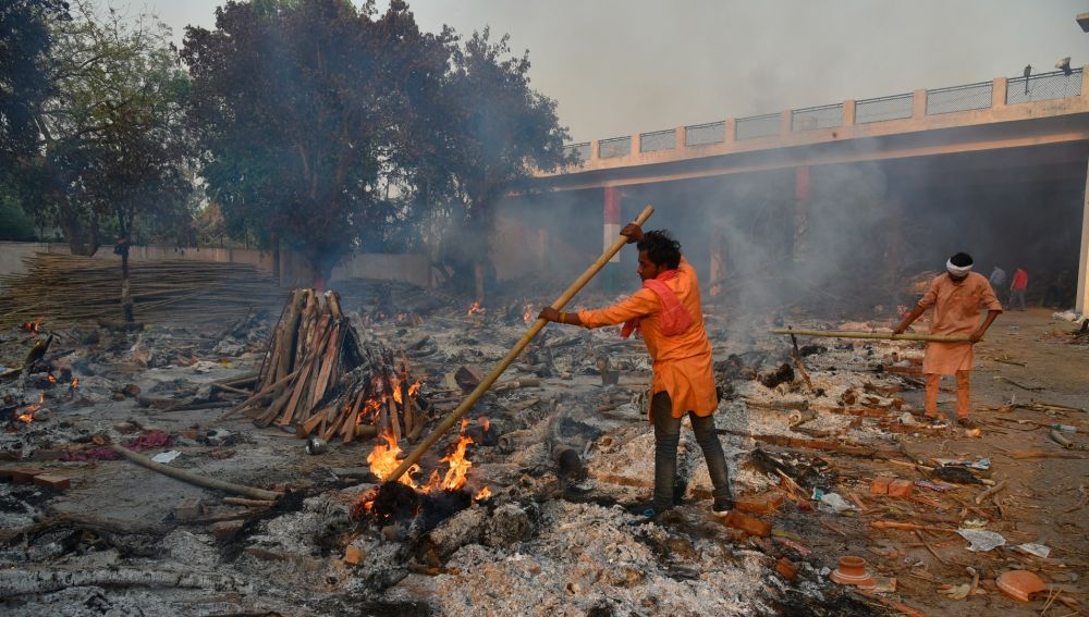 Un hombre quema cadáveres de fallecidos por coronavirus en India