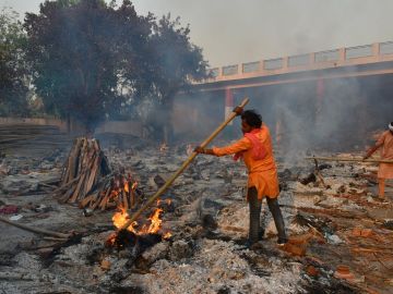 Un hombre quema cadáveres de fallecidos por coronavirus en India