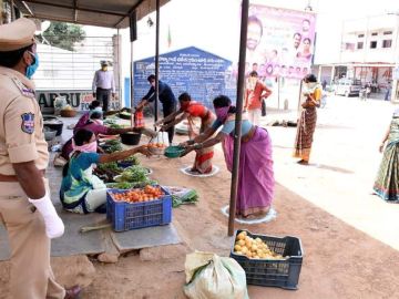Ciudadanos sale a hacer la compra bajo medidas de seguridad durante el confinamiento en la ciudad india de Anantapur.