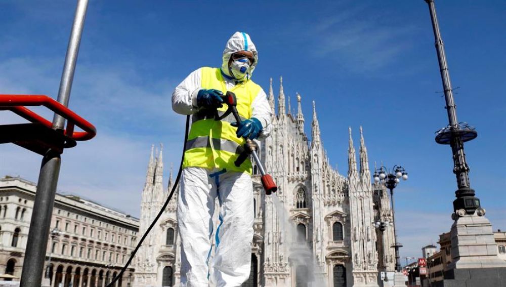 Imagen de una persona limpiando las calles en Italia con una mascarilla