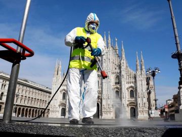 Imagen de una persona limpiando las calles en Italia con una mascarilla