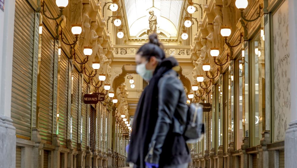 Una mujer pasea por Bruselas con mascarilla