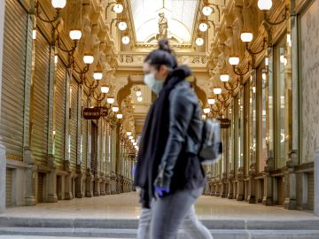 Una mujer pasea por Bruselas con mascarilla