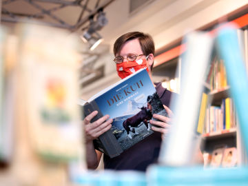Un ciudadano lee un libro en una biblioteca de Alemania